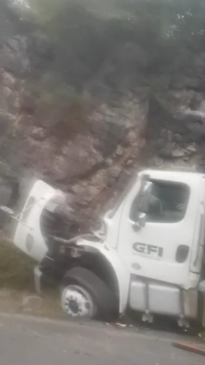 Choca camión cargado de madera contra el cerro